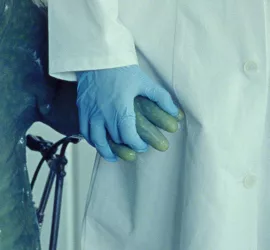 Une main gantée de scientifique tient la patte d'un triton à taille presque humaine dans le film The Newt Congress sélectionné au festival Court-Métrange.
