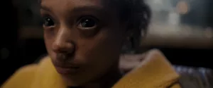 Plan rapproché-épaule sur une jeune fille aux yeux possédés, tout noirs dans le film La main.