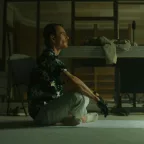 Michael Fassbender en position du lotus, vu de profil, sur un tapis de yoga, dans un appartement désaffecté ; plan issu du film The Killer.