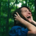 Julia Roberts hurle dans la forêt en se tenant la tête dans le film Le monde après nous.
