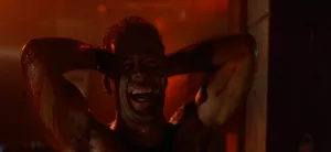Bruce Willis couvert de suie, hilare dans le film Die Hard : Piège de Cristal.