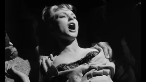Une belle jeune femme blonde attachée hurle, plan en noir et blanc du film Horror Hotel.