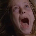 Plan rapproché-épaule sur une enfant blonde qui hurle dans son lit ; extrait du film Manhattan Baby.