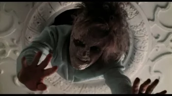 Une femme zombie surgit d'un lustre au plafond dans le film Réveillon Sanglant.