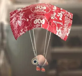 Marcel le coquillage dans les airs, utilise un paquet de bonbons en guise de parachute.
