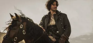 François Civil sur son cheval, sous un ciel gris, les cheveux au vent dans Les Trois Mousquetaires : Milady.