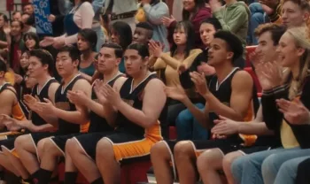 L'équipe de basket du film Prom Pact produit par Disney applaudit sur le banc près du terrain.