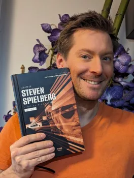 Le CinématoGrapheur pose avec le livre sur Steven Spielberg qu'il a écrit, tout sourire.