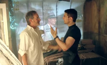 Steven Spielberg en plein échange avec Tom Cruise sur le tournage de Minority Report ; ils échangent devant une tôle blanche sur laquelle est diffusée une image de Frank Sinatra.