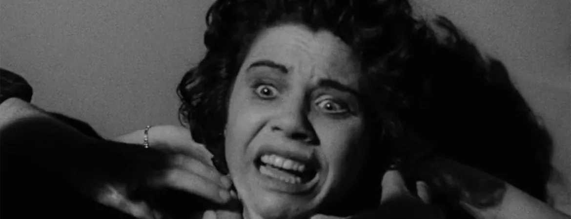 Gros plan, en noir et blanc sur une femme apeurée, des mains, en ombre, tentent de l'étrangler ; issu du film Dementia projeté au festival Extrême CInéma 2024.