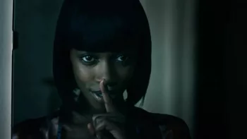 Jessica Allain pose son doigt devant sa bouche pour dire Chut, avec un sourire malicieux, dans le film Fear (2022).