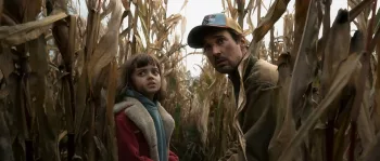 Dans The Signal, un papa, casquette sur la tête et sa petite fille surgissent d'un champ de maïs, et regardent derrière eux, l'air inquiet.