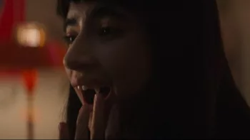 Gros plan sur une jeune fille qui touche sa dent de vampire, dans le film Vampire humaniste cherche suicidaire consentant d'Ariane Louis-Seize.