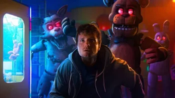 L'acteur John Hutcherson est poursuivi par trois animatroniques géants, des ours et des loups dont les yeux rouges et la gueule ouverte semblent déterminés à le croquer ; scène du film Five Nights at Freddy's.