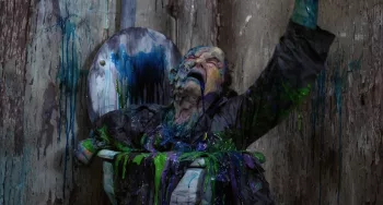 Un homme en costume-cravate est en train de foudre sous l'effet d'in liquide bleu et vert, dégoulinant dans le film Street Trash de Jim Muro, diffusé au festival Extrême cinéma.