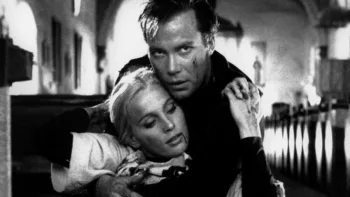 William Shatner tient dans ses bras une femme blonde, hagarde, avec su sang au coin de la bouche, dans une église, à ras du sol, dans le film Incubus.
