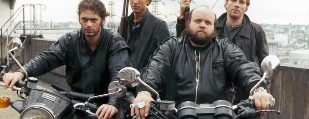 Les quatre loubards du film Brigade des Mœurs de Max Pecas, posent sur le motos armés, l'air provocateur, vêtus de leurs blousons noirs.