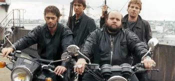 Les quatre loubards du film Brigade des Mœurs de Max Pecas, posent sur le motos armés, l'air provocateur, vêtus de leurs blousons noirs. 