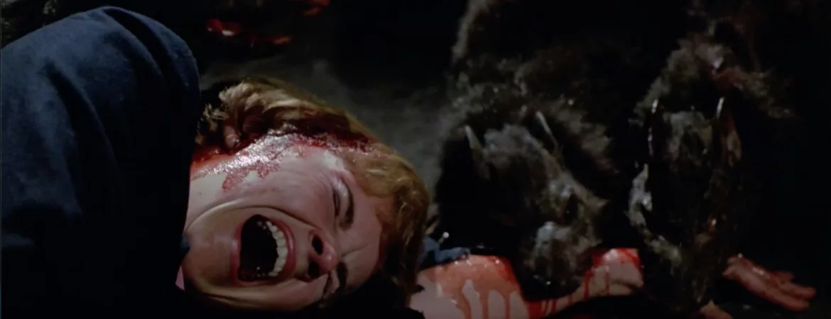 Deux rats géants dévorent le bras d'une femme hurlant à terre dans le film Les rats attaquent.