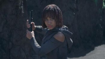 Amandla Stenberg prête au combat, tient un sabre laser entre ses mains, au pied d'une montagne dans la série The Acolyte.