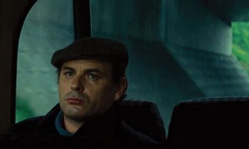 Jean-Francois Stevenin la mine sombre, dans une voiture, de nuit, dans le film Peaux de vaches.