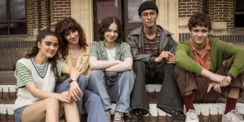 Les cinq jeunes de la série Meurtre mode d'emploi posent souriants sur les marches d'une maison.