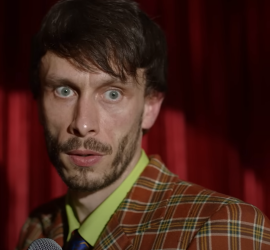 Plan rapproché-épaule sur Richard Gadd en plein spectacle de stand-up, l'air ahuri ; plan issu de Mon petit renne.