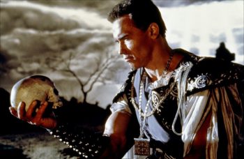 Arnold Schwarzenegger en costume d'époque, tient un crâne dans sa main comme Hamlet dans Last Action Hero réalisé par John McTiernan.