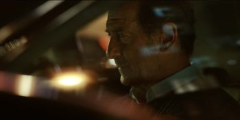 Plan rapproché-épaule sur Vincent Lindon, soucieux, au volant de sa voiture, vu à travers le pare-brise ; issu du film Le choix.
