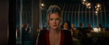 Plan rapproché-poitrine de face sur Meghann Fahy, au restaurant, regardant droit l'objectif dans une mine incompréhension ; issu du film Drop game.