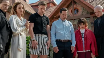 Plusieurs personnages, hommes et femmes, de tous âges, sont devant une belle maison ancienne ; ils regardent touts à leur pieds, visiblement tristes ; plan issu de Death of a unicorn.