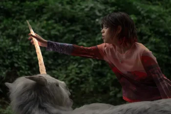 Jenna Ortega se risque à toucher la corne d'une licorne allongée au sol dans le film Death of a unicorn.