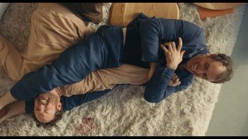 Michael Angelo Covino et Kyle Marvin se bagarrent en faisant une prise de soumission sur un tapis à moquette dans Libre Échange.