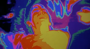 Vu en caméra thermique, un homme semble endormi ; plan du film Liquid sky.