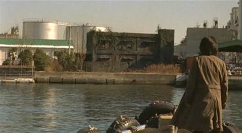 Un homme face à un bâtiment en ruine en bord de fleuve dans Retribution de Kiyoshi Kurosawa