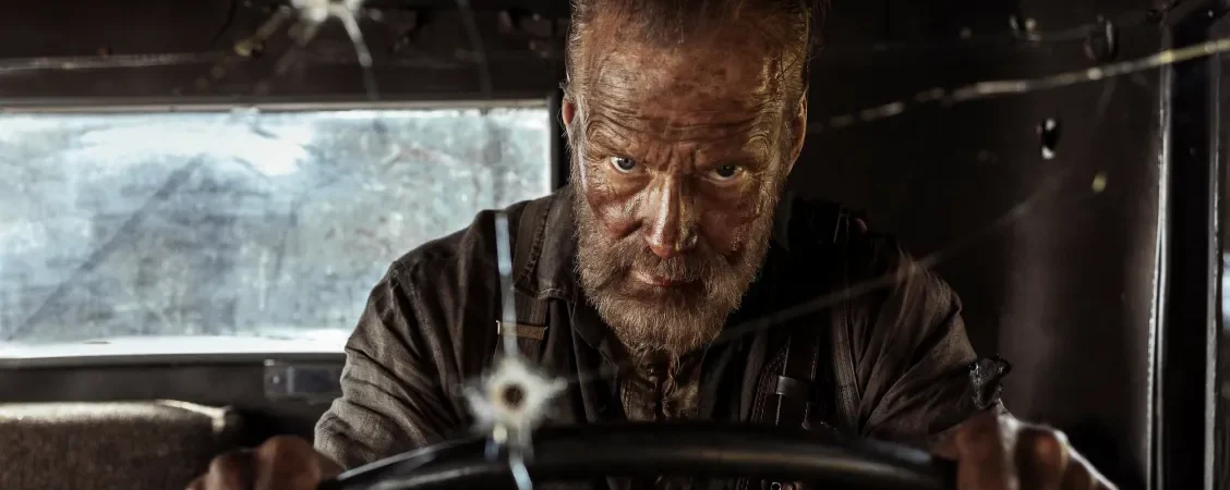 Jorma Tommila énervé au volant de son camion, le pare-brise trouée par un impact de balle dans le film SIsu - le chemin de la vengeance.