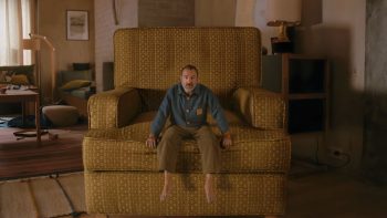 Jean Duajrdin miniaturisé sur un fauteuil dans le film L'homme qui rétrécit réalisé par Jan Kounen.