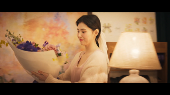 Han So-hee dans Project Y, contemplant un bouquet de fleurs.