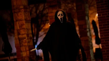 Ghostface, prêt à frapper, un couteau dans la main, dans une cave en pierre dans Scream 7.