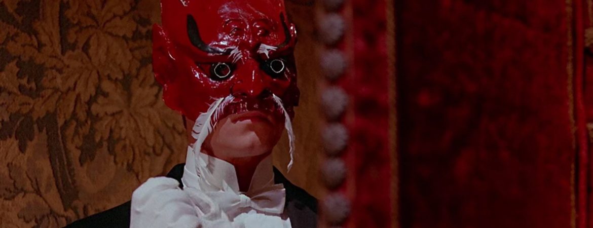 Un personnage portant un étrange masque rouge dans Le Baiser du Vampire