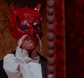 Un personnage portant un étrange masque rouge dans Le Baiser du Vampire