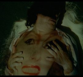 Projection d'un visage de femme sur le torse d'un homme se caressant.