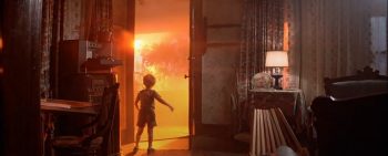 Enfant ouvrant la porte sur un paysage en feu