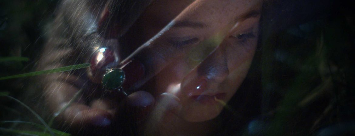 Visage d'une jeune fille en surimpression avec une main portant une bague à pierre verte.