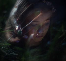 Visage d'une jeune fille en surimpression avec une main portant une bague à pierre verte.