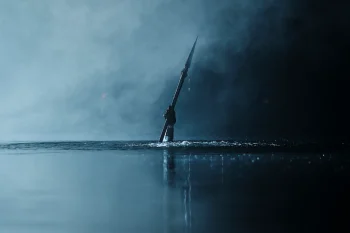 Une main tenant une lance se dresse hors d'une étendue d'eau placide ; le ciel est gris bleu, sombre, et s'apparente à la couleur de l'eau ; plan du film TEENAGE SEX AND DEATH AT CAMP MIASMA, présenté à Cannes 2026.