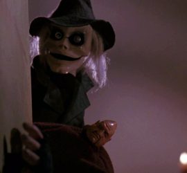 Les poupées Blade et Pinhed se cachent derrière un mur blanc, observant, dans le film Puppet Master.