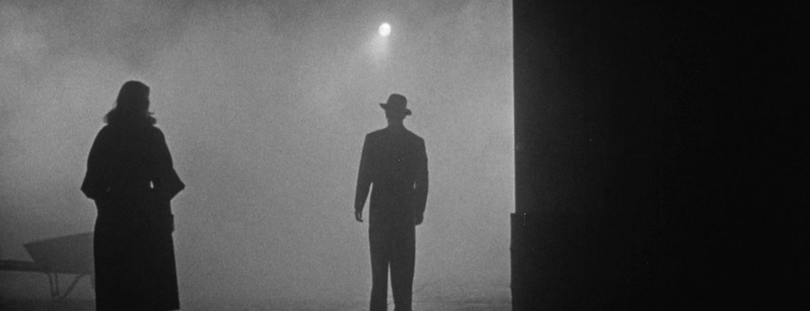Plan large, de nuit, brumeux, sur deux silhouettes, un homme et une femme qui se font face dans le film The big combo réalisé par Joseph H. Lewis abordé dans Trois maîtres du cinéma modeste.