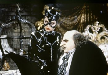 Le pingouin et Catwoman en train de parler dans une chambre, près d'une cage à oiseaux.