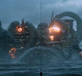 Le kraken attaque avec ses tentacules un bateau sur la mer, dans une lumière bleutée ; avec des flammes qui s'échappent du bateau.
